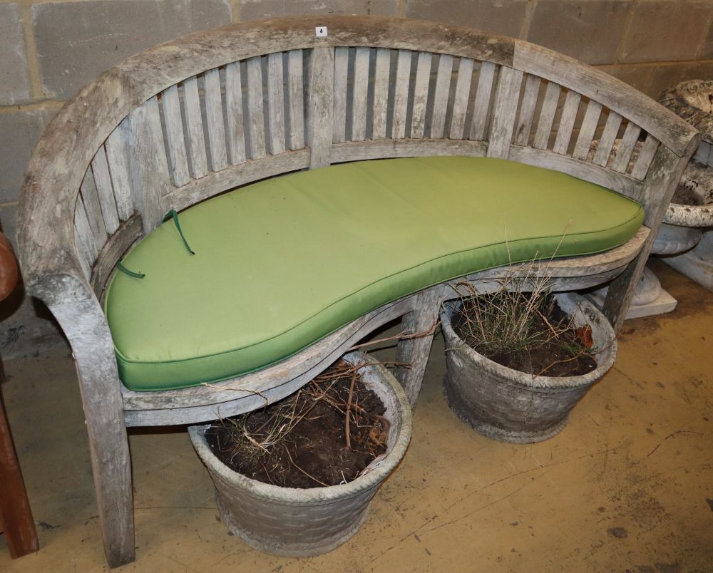 A weathered teak garden banana bench with cushion, W.160cm, D.60cm, H.85cm